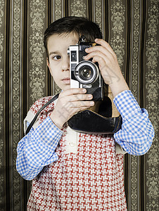 拿着老式相机的男孩复古服装背景图片