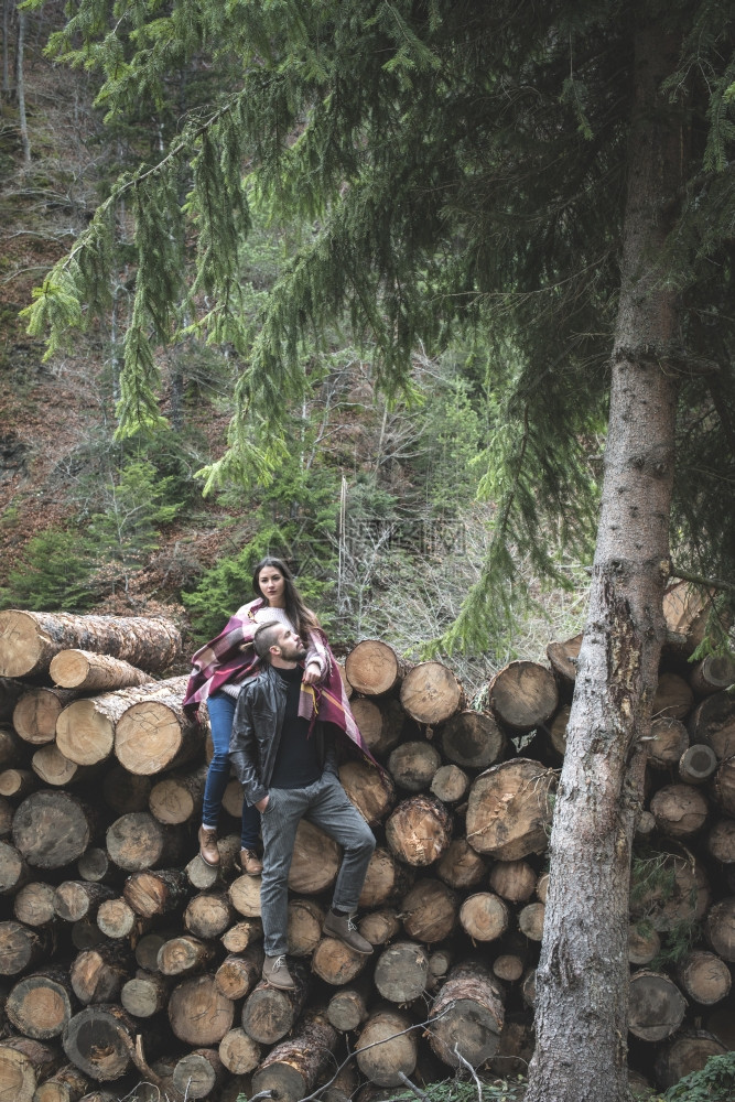 在森林原木上的男女青年图片