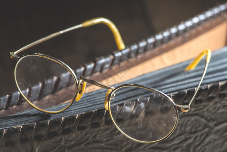 古老的圆环眼镜和皮革相册图片