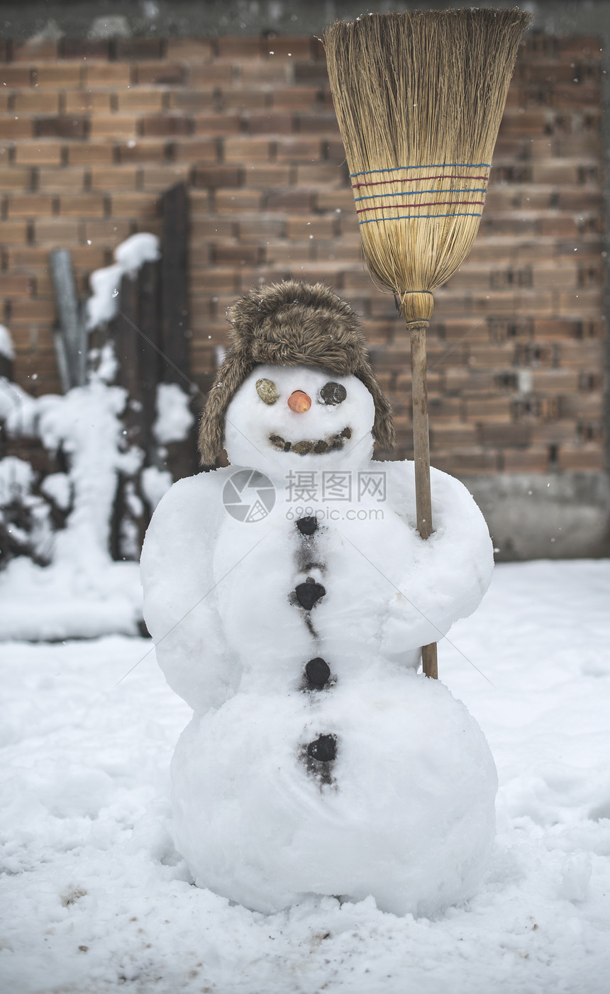 在院子里的雪人拿着扫帚图片