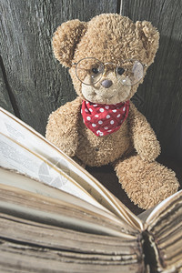 儿童泰迪熊与旧书图片