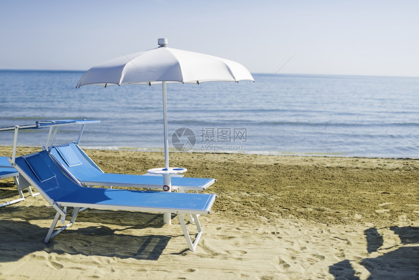 沙滩上的蓝色防晒霜和雨伞图片