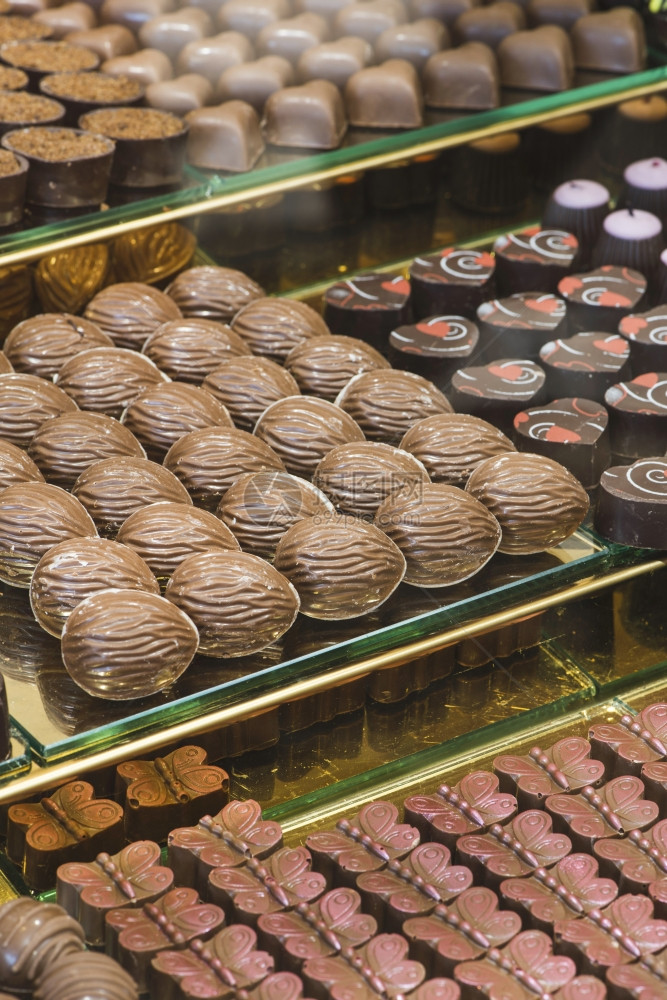 在商店窗户的巧克力糖果与站在一起图片