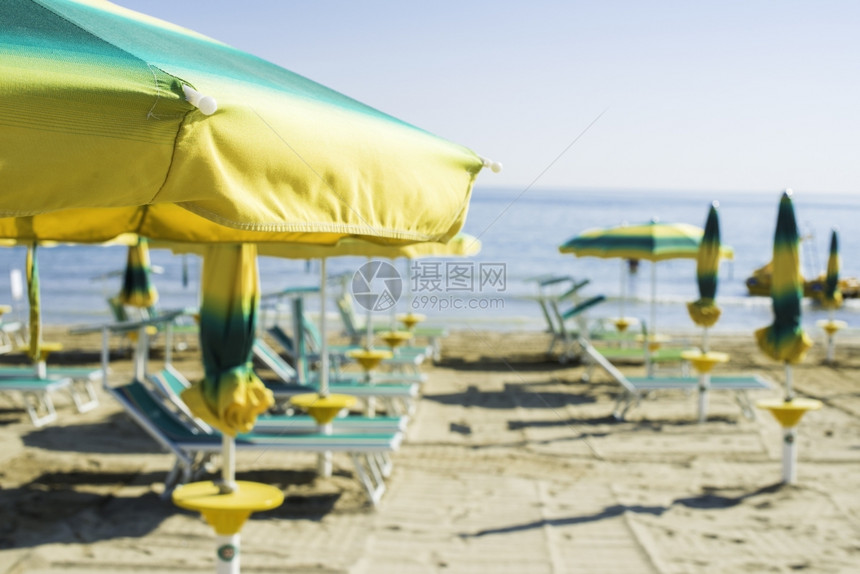 沙滩上绿色的防晒霜和雨伞图片