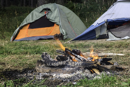 森林中两个帐篷前方着火图片