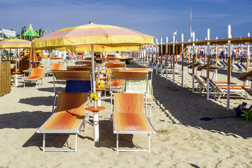 沙滩上的橙色太阳床和雨伞图片