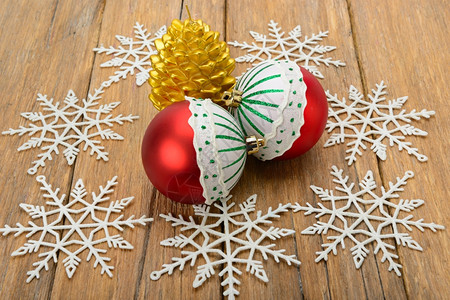 圣诞节装饰品花锥形蜡烛和木表面的雪花图片