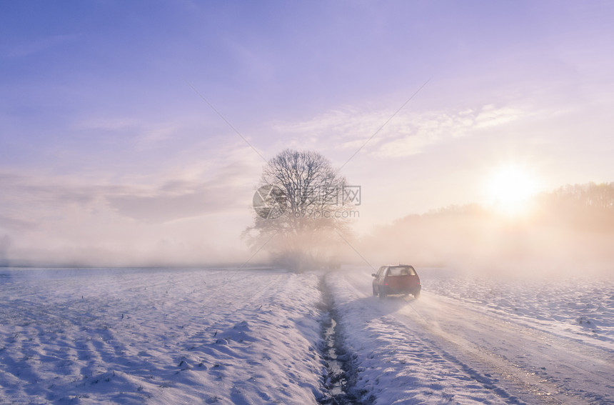 冬天行驶在农村雪地的汽车图片
