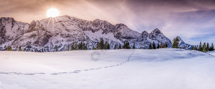 冬季风景有奥斯特里亚山峰雪上一小条脚步在片戏剧化和多彩的天空下背景图片