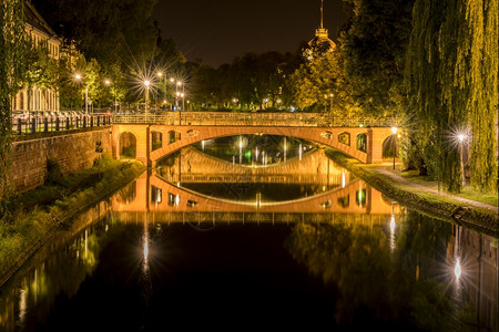 美丽的水反射在晚上河两座中世纪的石桥在法国斯特堡背景图片
