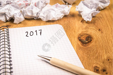新年概念在图表螺旋笔记本和折叠页上写有2017年概念其背景表明岁月已经过去背景图片