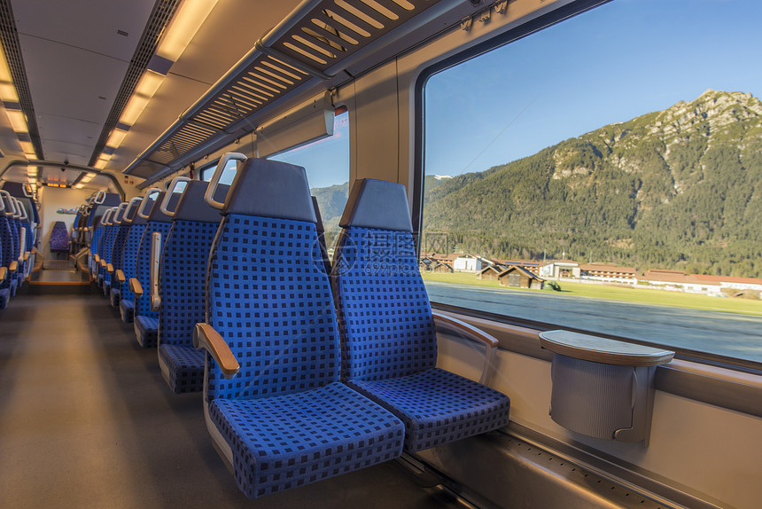 在现代德国列车上坐着舒适的椅子窗外有美丽的高山风景图片