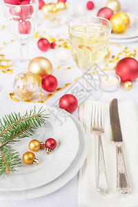 白瓷花板葡萄酒杯桌布的子上铺有白布的刀和叉子圣诞舞会和绿树枝图片
