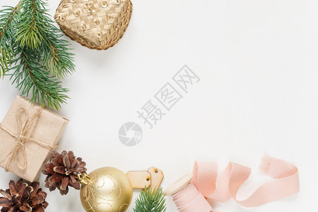圣诞节框架由圆枝锥形礼品盒圣诞节金球和白色背景的粉丝带组成图片