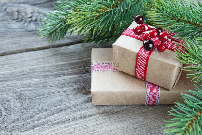 圣诞框架由绿色的葡萄树枝松果木板背景上含胡利果的礼品盒贺卡网站社交媒体杂志博客艺术家等固定的构成组图片
