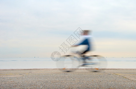 不明身份者驾驶自行车在海面堤岸上驾驶图片