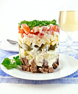 加牛肉煮土豆泡菜芝士番茄盘子里的欧斯利白葡萄酒蓝布桌背景的白葡萄酒图片