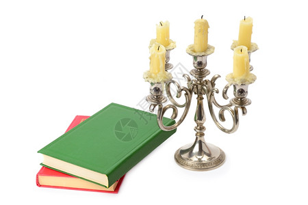 与白背景孤立的蜡烛和书籍相纠缠图片