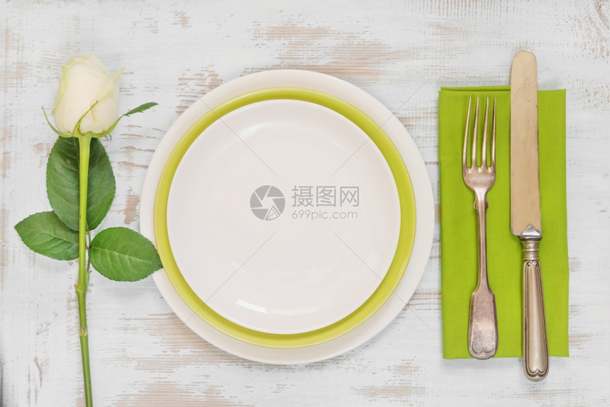 白色和绿空板纸巾旧叉刀和白玫瑰花放在旧木板桌上顶视平躺图片