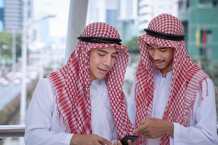 阿拉伯商人用手机介绍商业概念图片