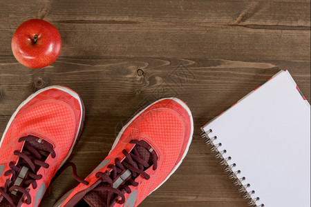 妇女鞋和记录木地板体育成就的笔记本图片