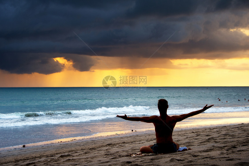 一个在海滩上做瑜伽锻炼的人背影bali岛印度图片