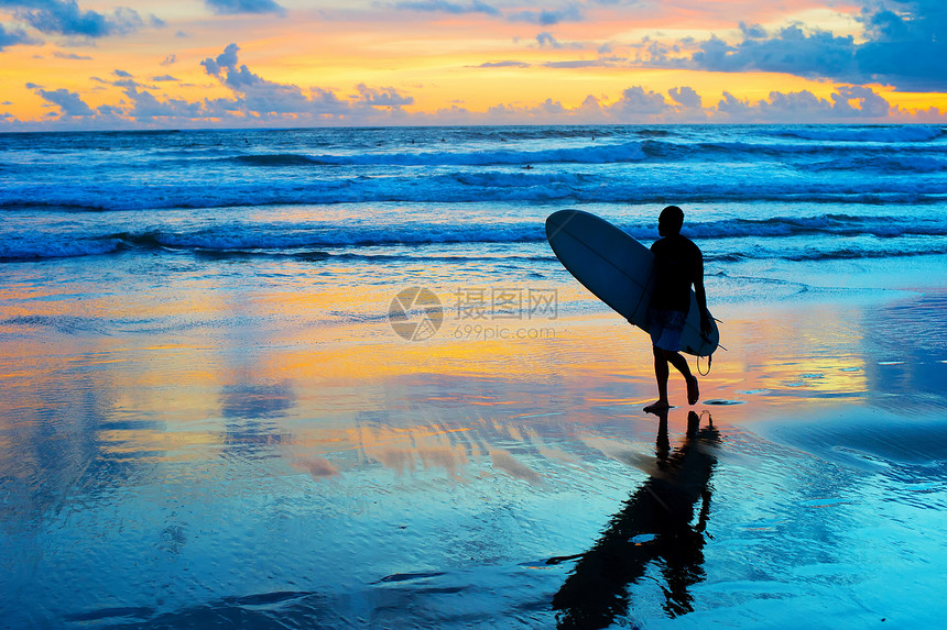 日落时冲浪机向湿沙滩图片