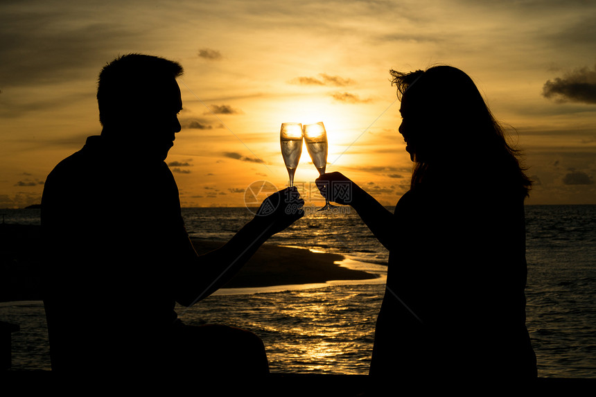 夫妻在热带假日享受一杯葡萄酒图片