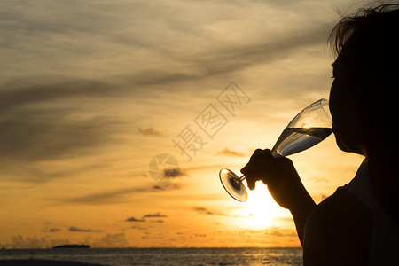 对月饮酒美丽日落时以酒配着女休月背景