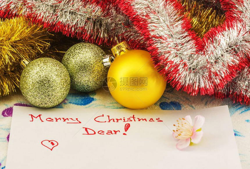 写在一张纸上面写着圣诞问候旁边的床单是说谎圣诞节球和装饰的meshura图片