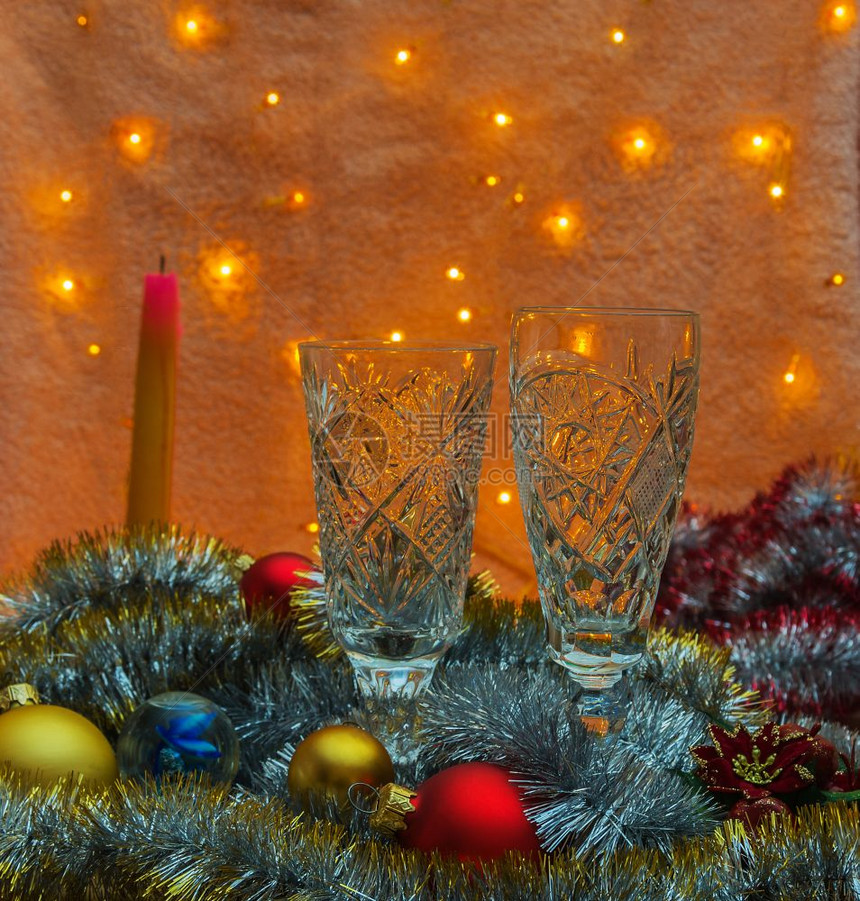 在阴暗的中有两杯香槟熄灭了蜡烛和圣诞装饰品图片