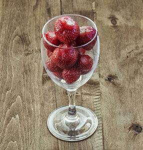 木板表面是玻璃葡萄酒杯有草莓图片