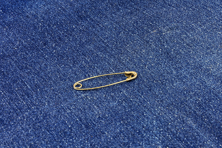 蓝色牛仔裤材料上的金属扣针高清图片