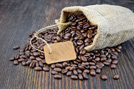 黑咖啡豆袋木板背景上的标签背景图片