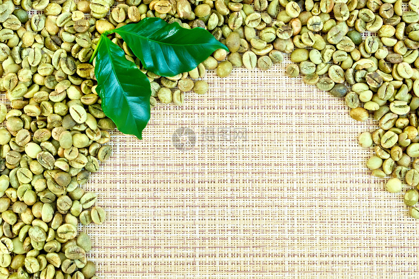 绿色咖啡豆框架黄粗织布上有叶子图片