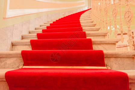 从一个被红色地毯覆盖的豪华楼顶上高压室内大理石楼梯图片