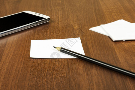桌子表面是智能手机和铅笔记本用纸板图片