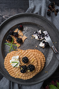 美味的早餐贝吉亚华夫饼和新鲜的野生黑莓和底的奶油酪图片
