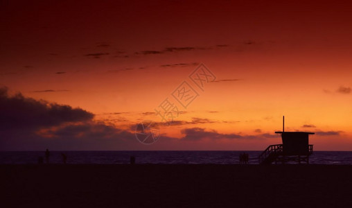 日落时候的救生塔在埃莫萨海滩加州洛斯天使城在背景平静的水中图片