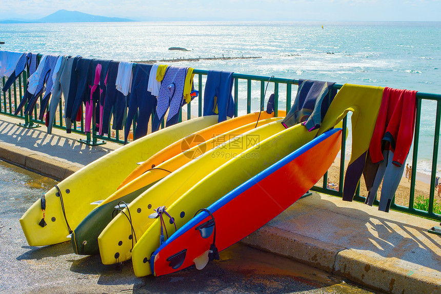 冲浪板和湿衣在海滩上烘干图片