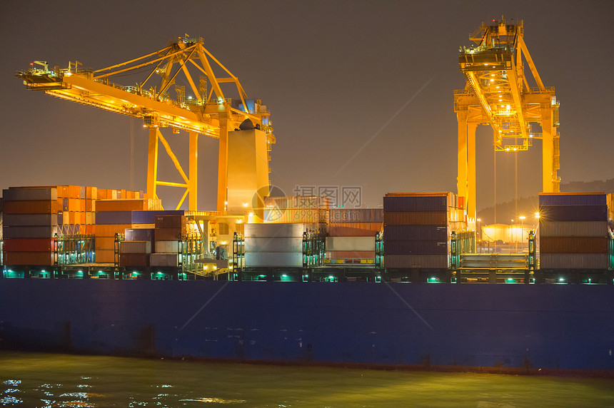 夜间商业港口的起重机船舶和集装箱图片