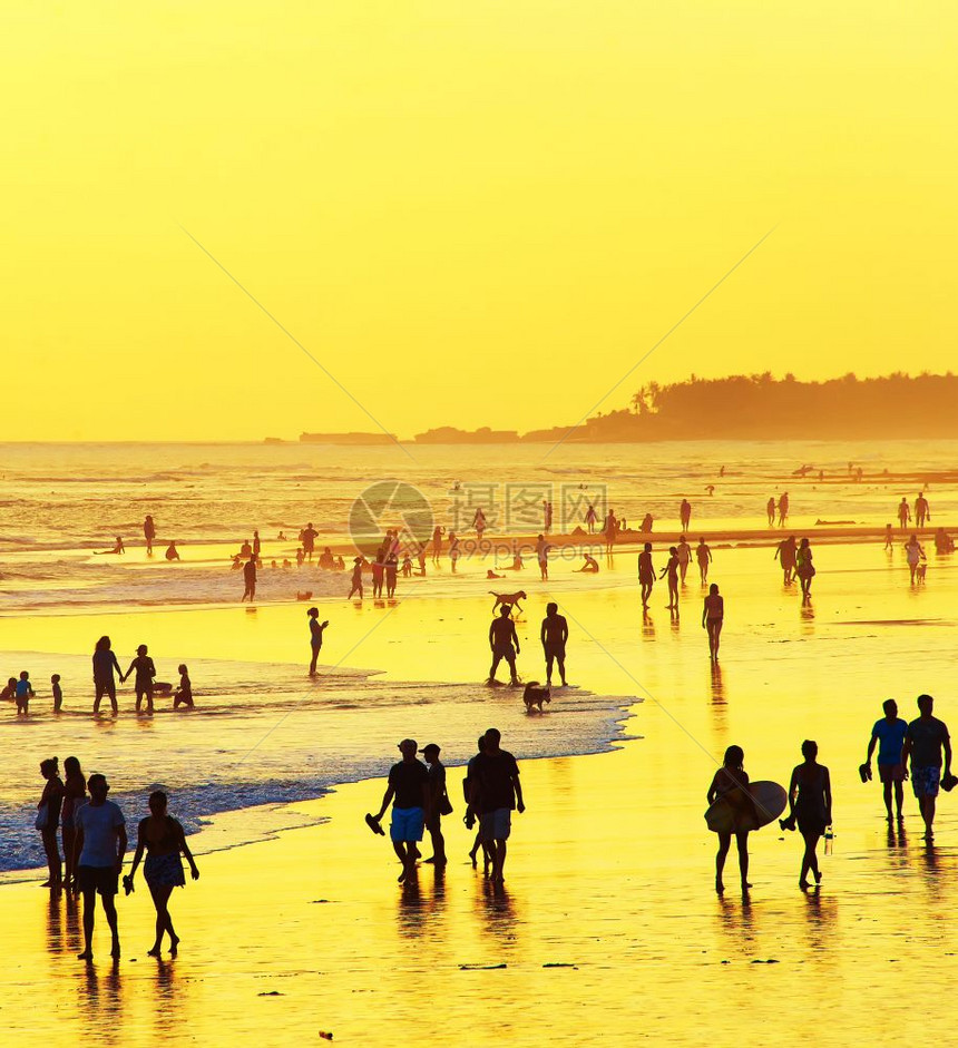 日落时在海滨上行走的人图片