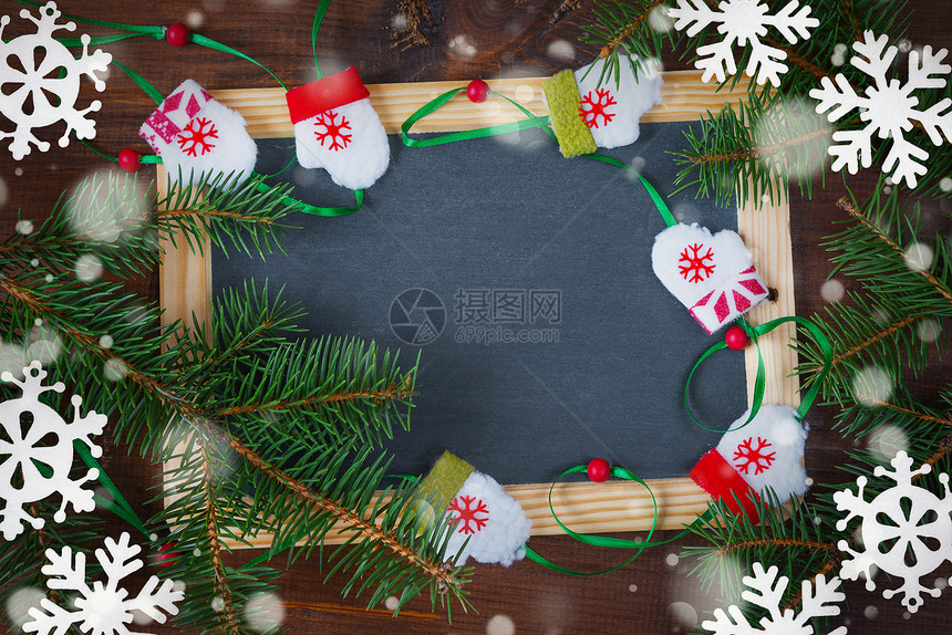 在古代风格中美丽的圣诞卡空白黑板周围环绕着绿色的圆形枝和白感觉着带复制空间的雪花图片