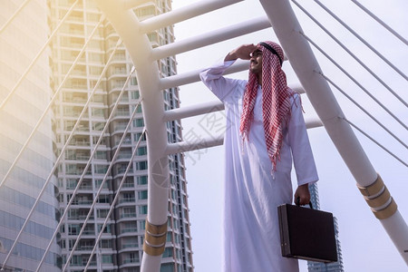 有自信的阿拉伯商人站立一看城市背景展望概念高清图片
