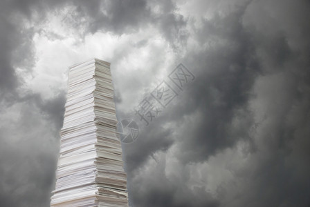 在乌云笼罩的暴风天空背景下堆叠厚的纸图片