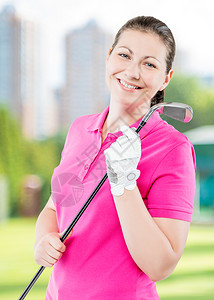 快乐的高尔夫球手在场背景微笑和举行高尔夫俱乐部图片