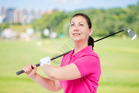 具有高尔夫球场背景打高尔夫球设备的成功高尔夫球手横向肖像图片