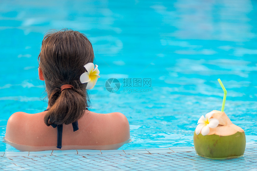 女孩与椰子在游泳池中的肖像图片