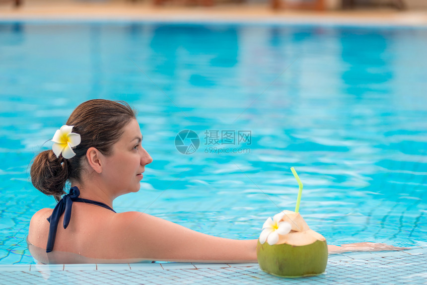 女孩与椰子在游泳池中的肖像图片