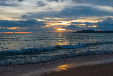 波浪卷海浪在夜晚美丽的日落沙滩上滚动背景